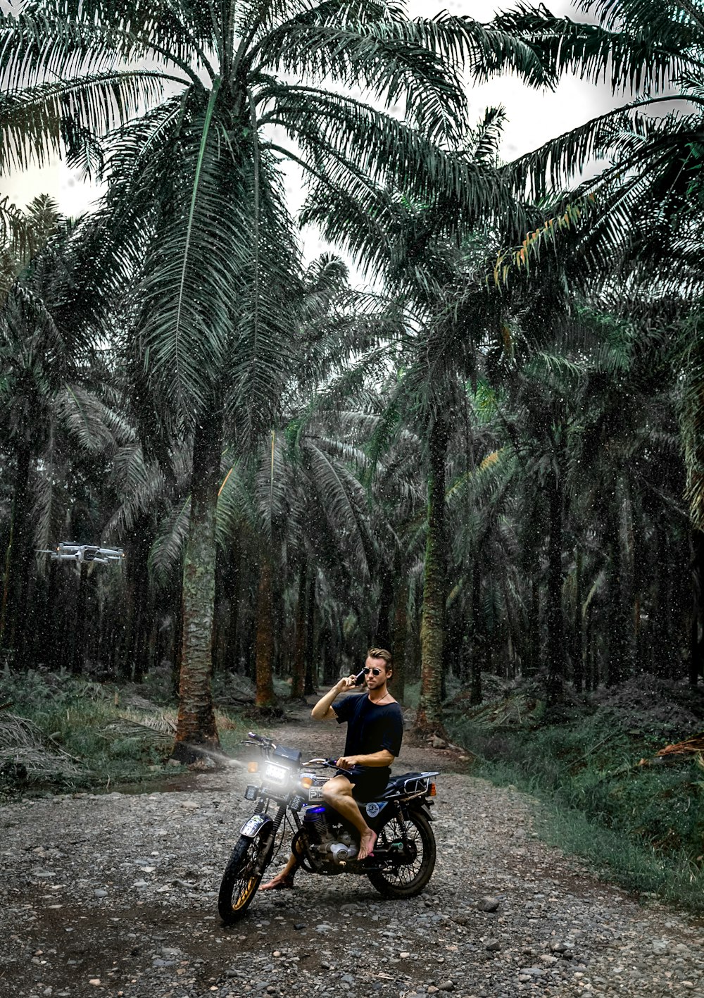 a man sitting on a motorcycle in the middle of a forest