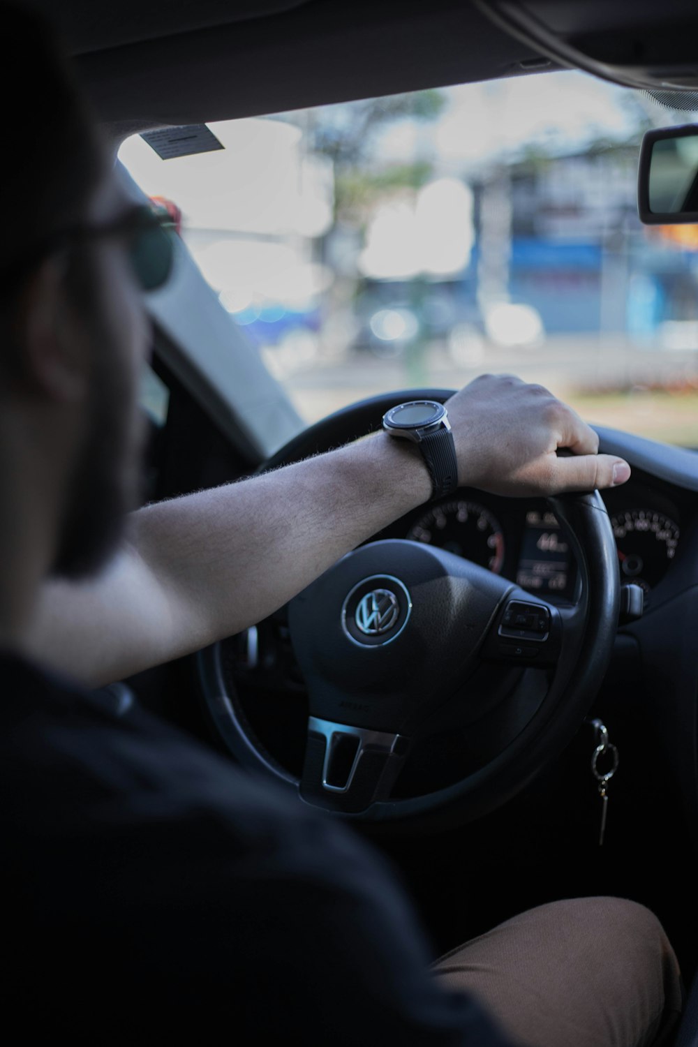 A man driving a car with his hand on the steering wheel photo