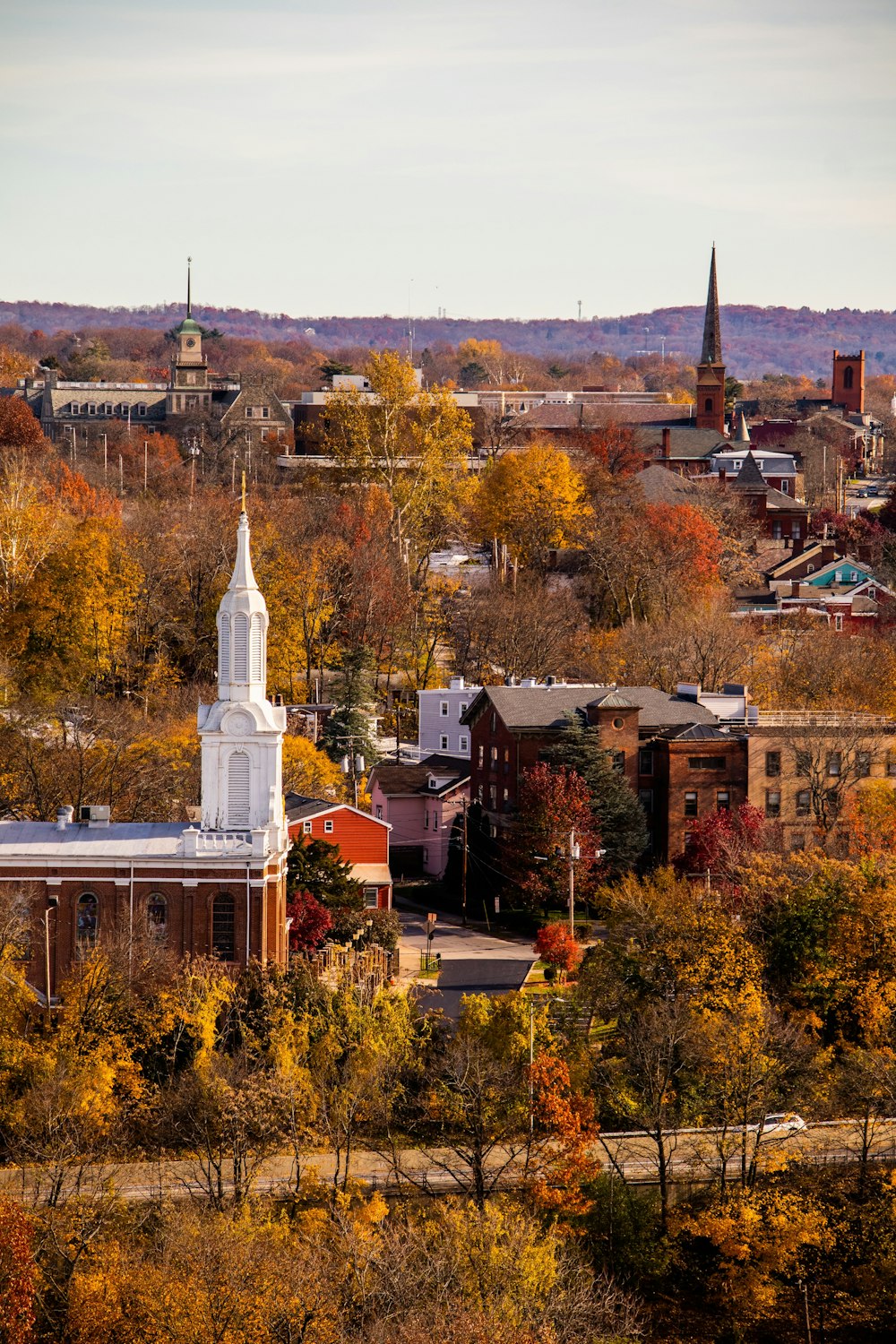 a small town with a white steeple surrounded by trees