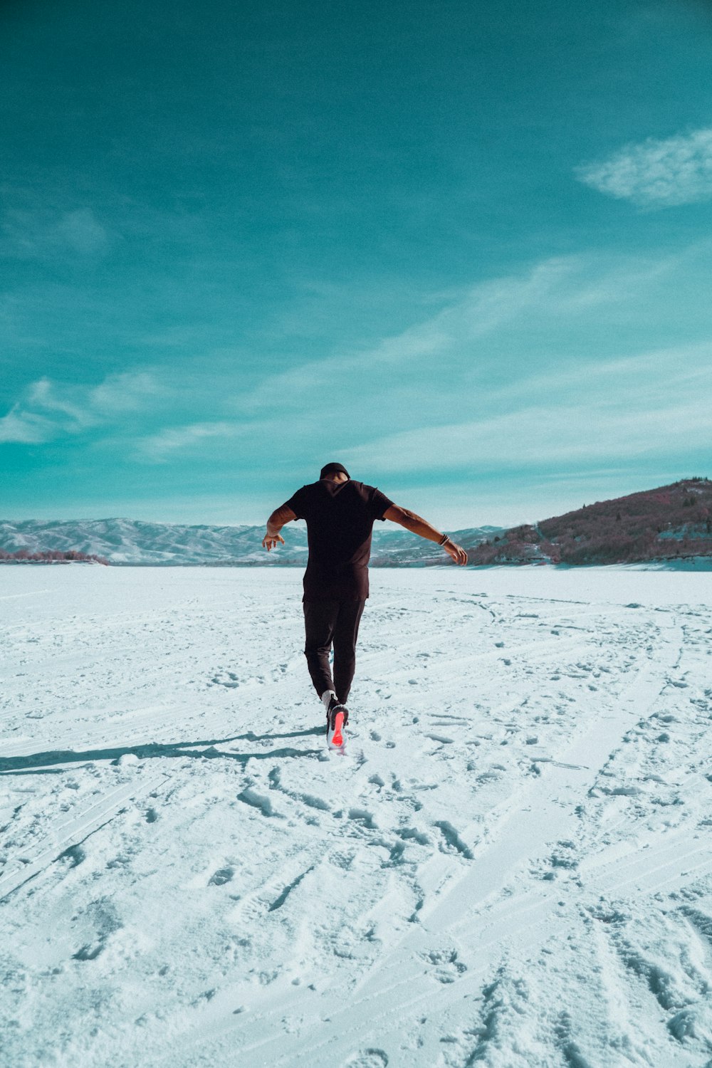 a man running across a snow covered field