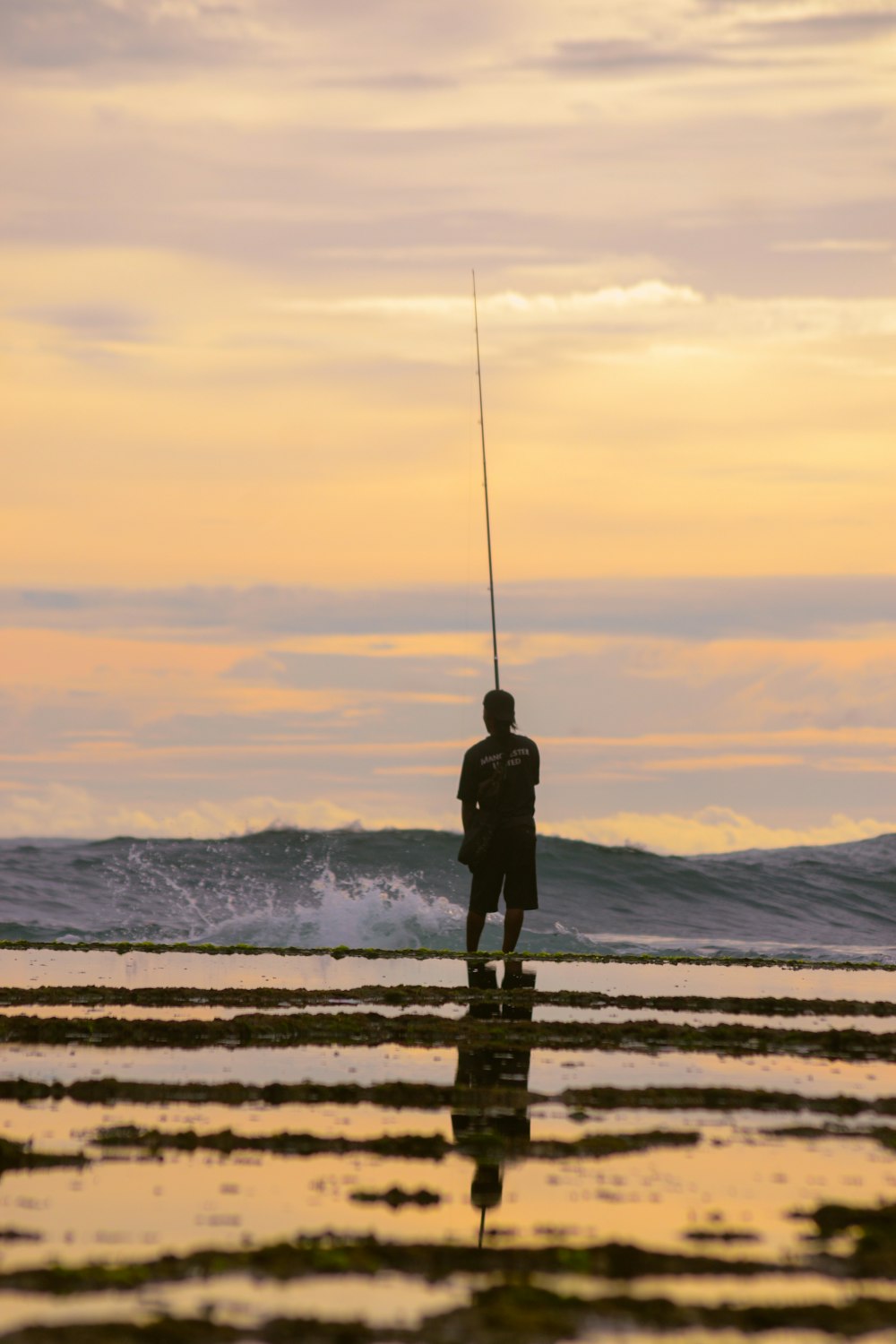 a man standing on top of a beach next to the ocean