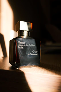 a bottle of perfume sitting on top of a wooden table