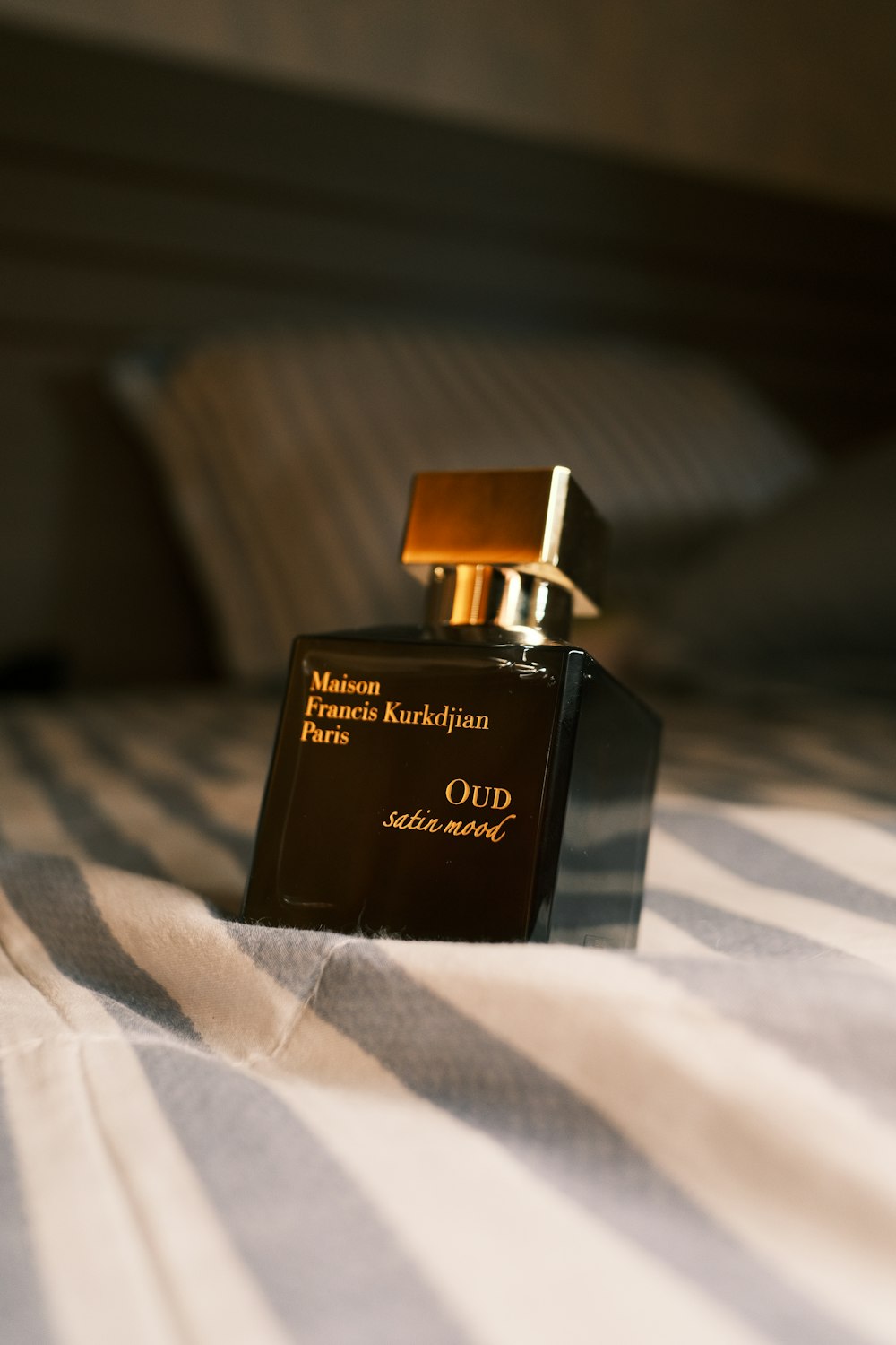 a bottle of perfume sitting on top of a bed