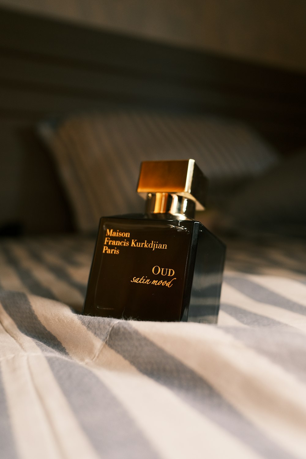 Una botella de perfume encima de una cama