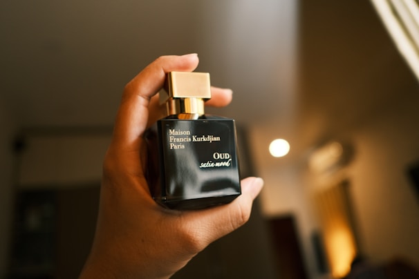 a person holding a bottle of perfume in their hand