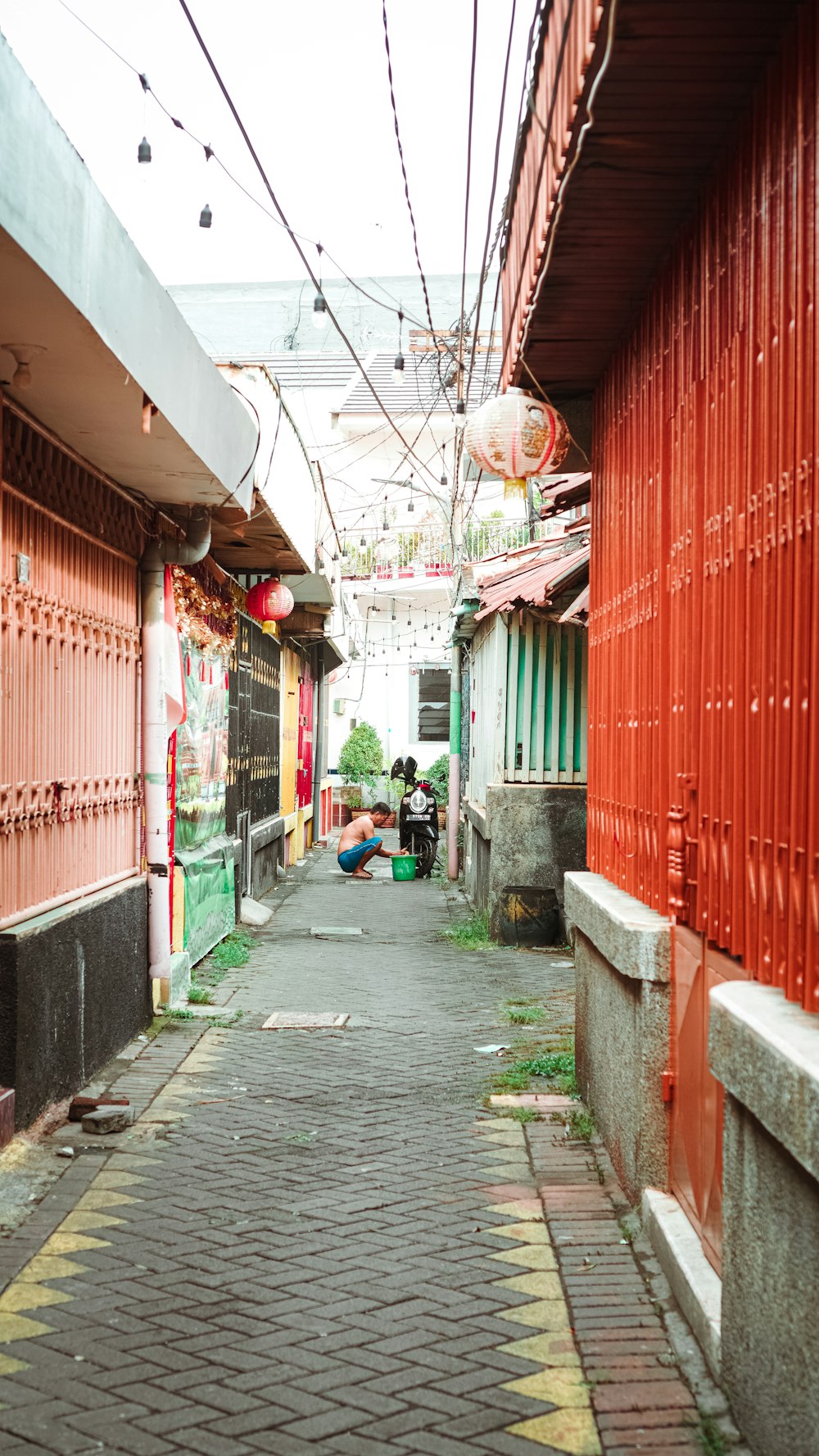 a narrow alley way with red and green buildings