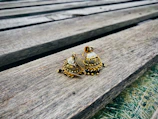Pair of exquisite gold earrings resting on a polished wooden surface.