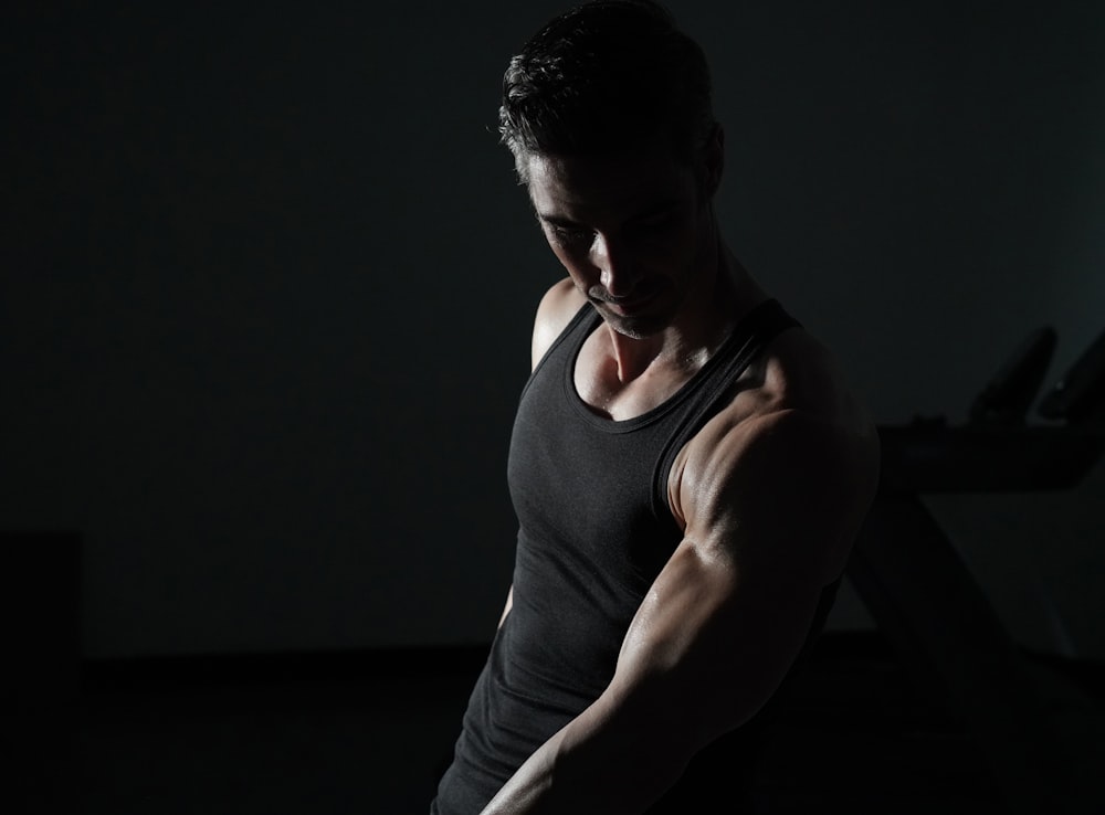 a man in a black tank top is doing exercises