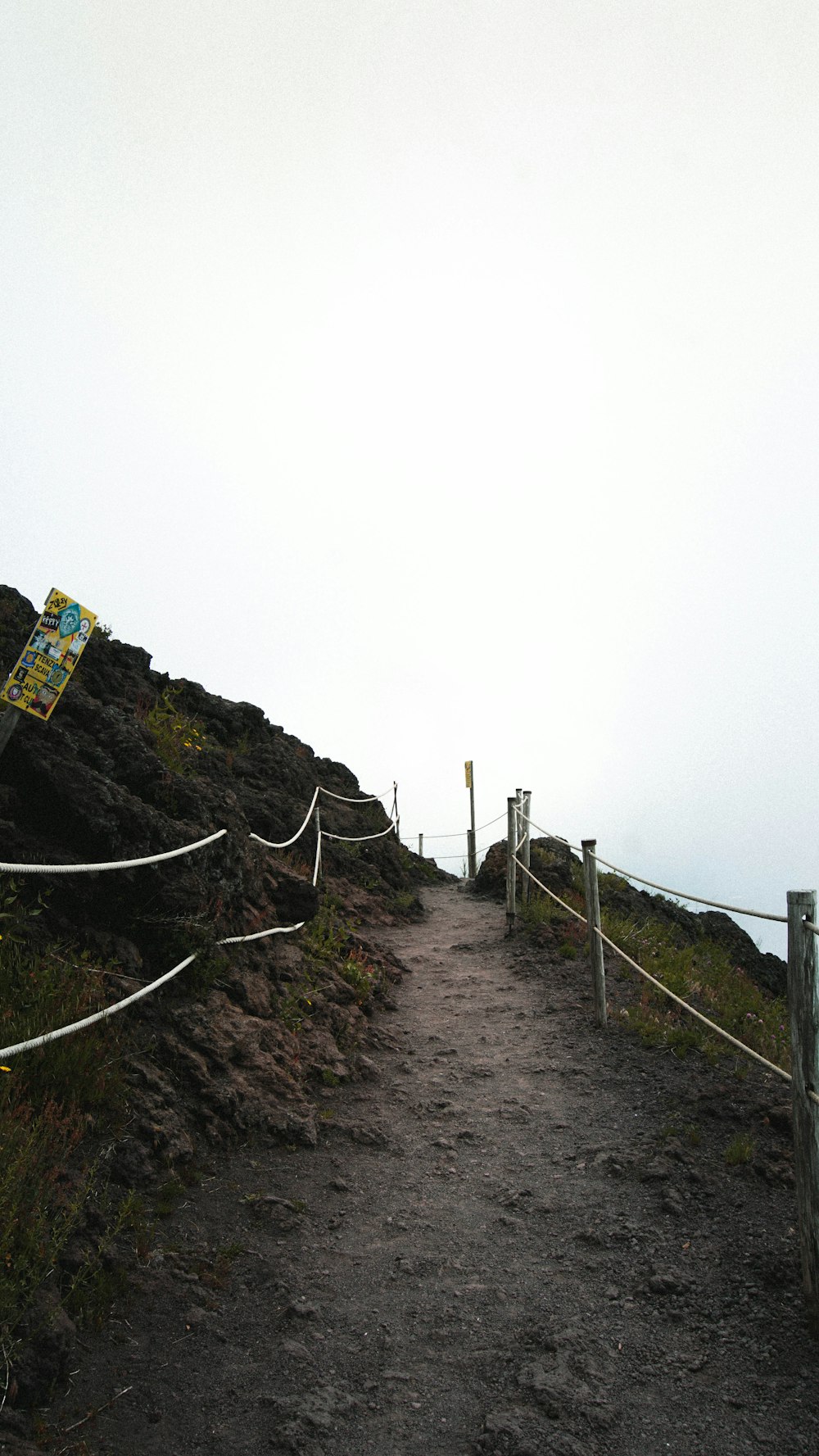 a path leading to a sign on top of a mountain