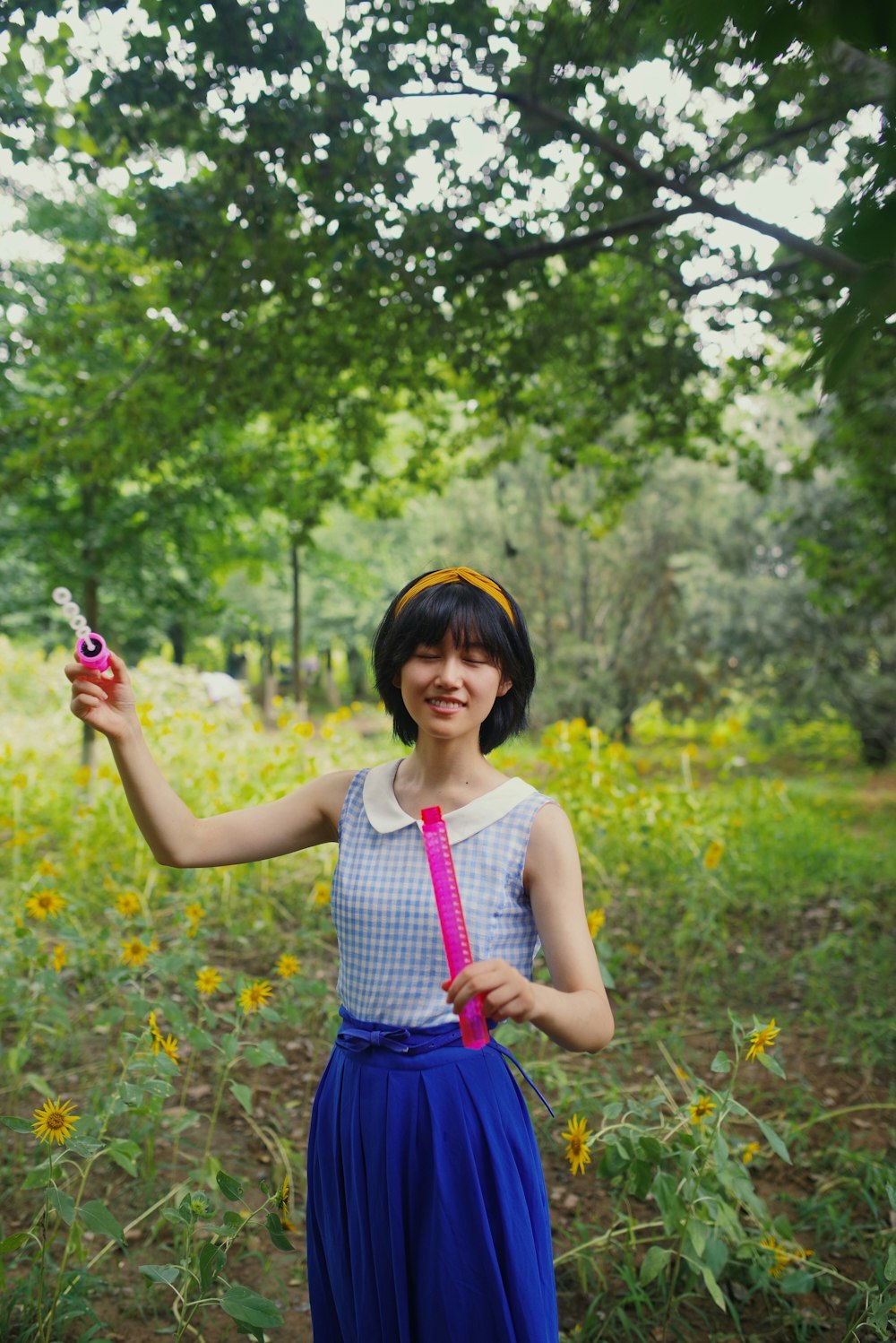 a woman in a blue dress holding a pink object