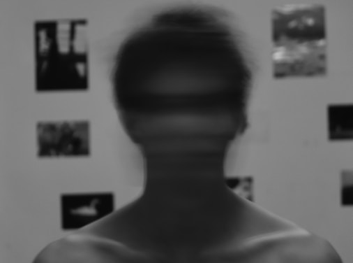 a blurry image of a man's face in front of a wall with