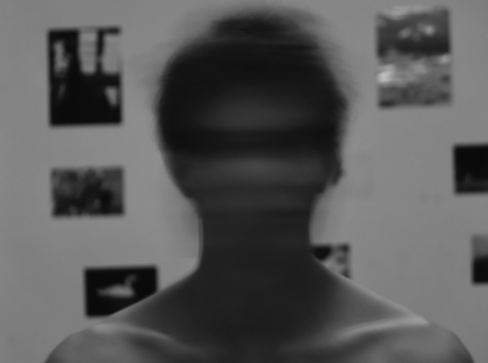 a blurry image of a man's face in front of a wall with