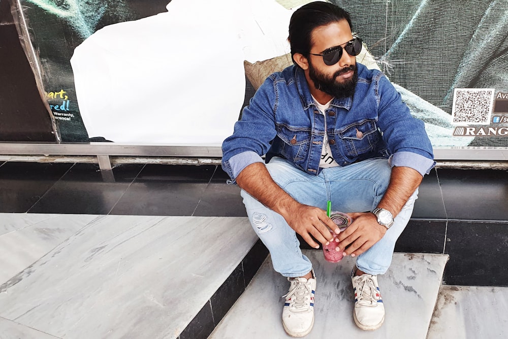 a man sitting on a step with a drink in his hand