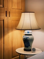Close-up of a ceramic lamp with ocean-inspired blue glaze on a bedside table.