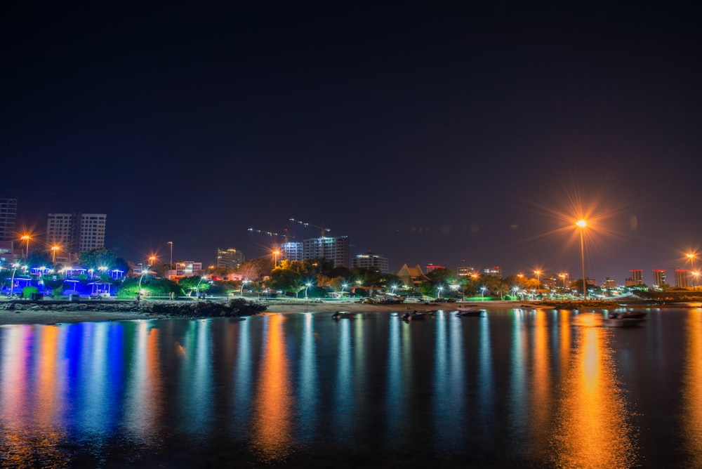 a night view of a city with lights reflecting in the water