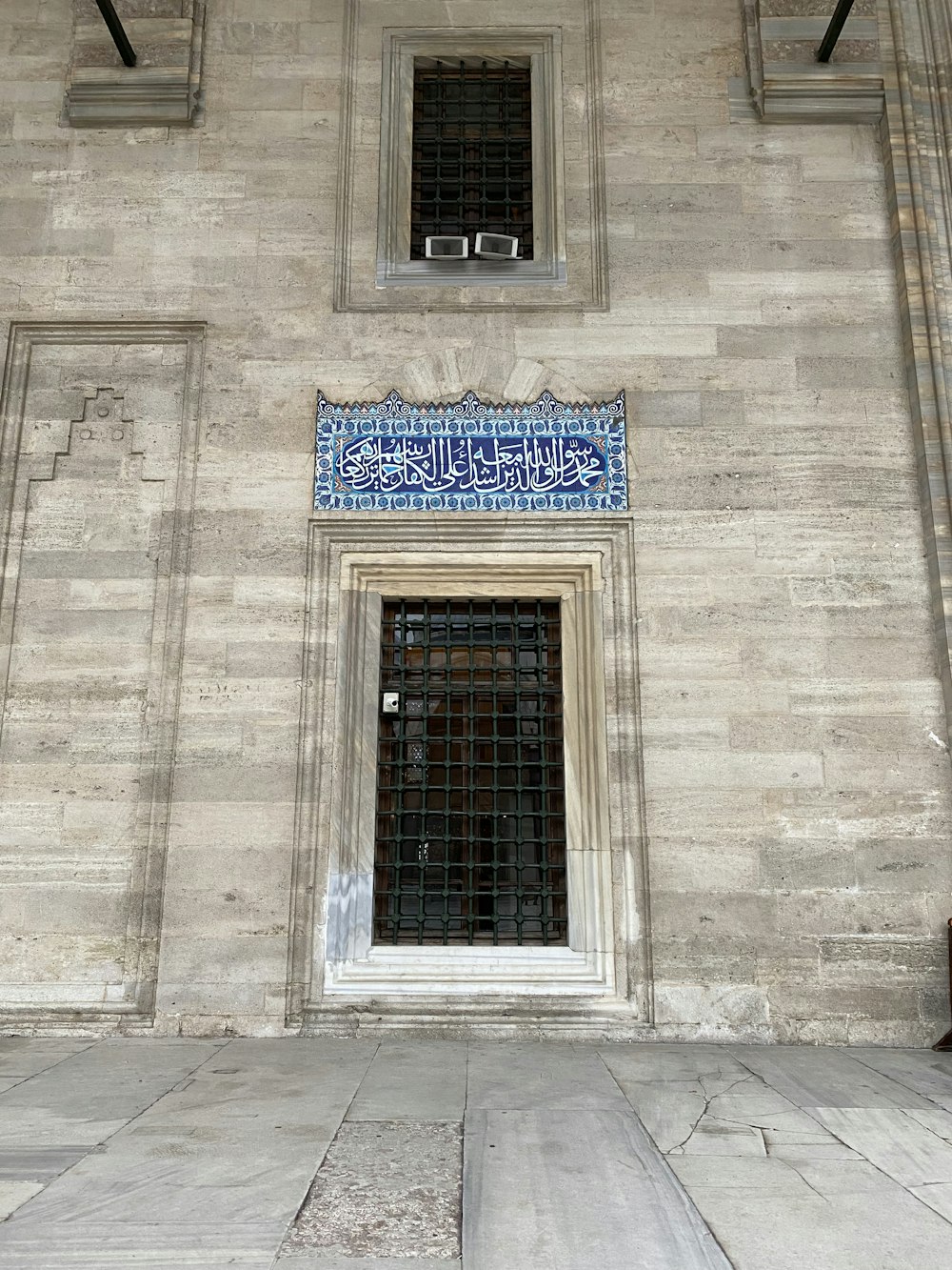 a building with a window and a blue tile design on the side