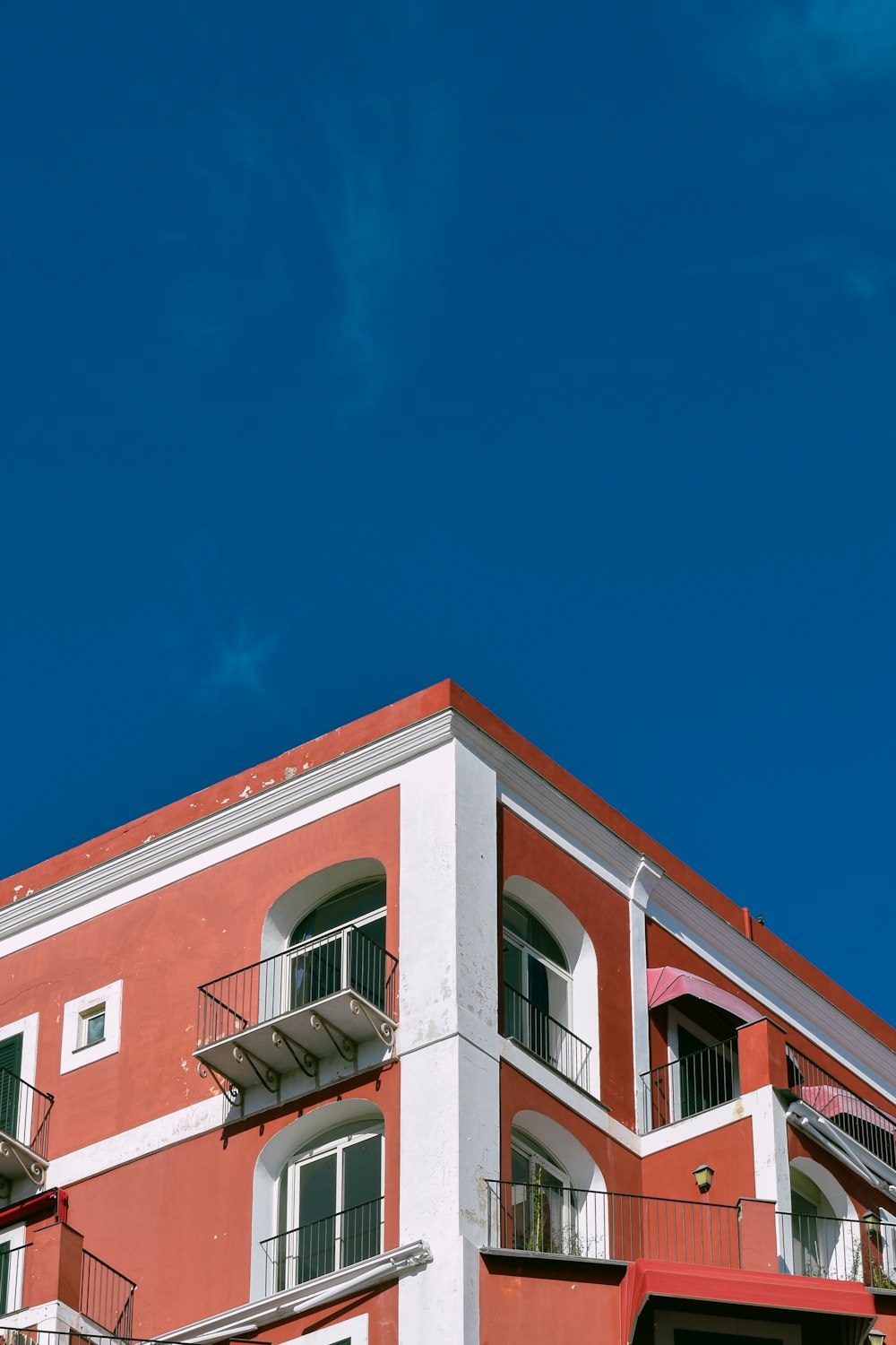 a red and white building with balconies and balconies