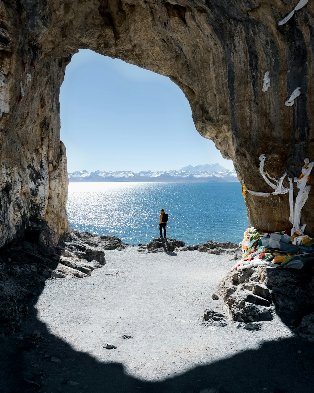 a person standing at the entrance to a cave