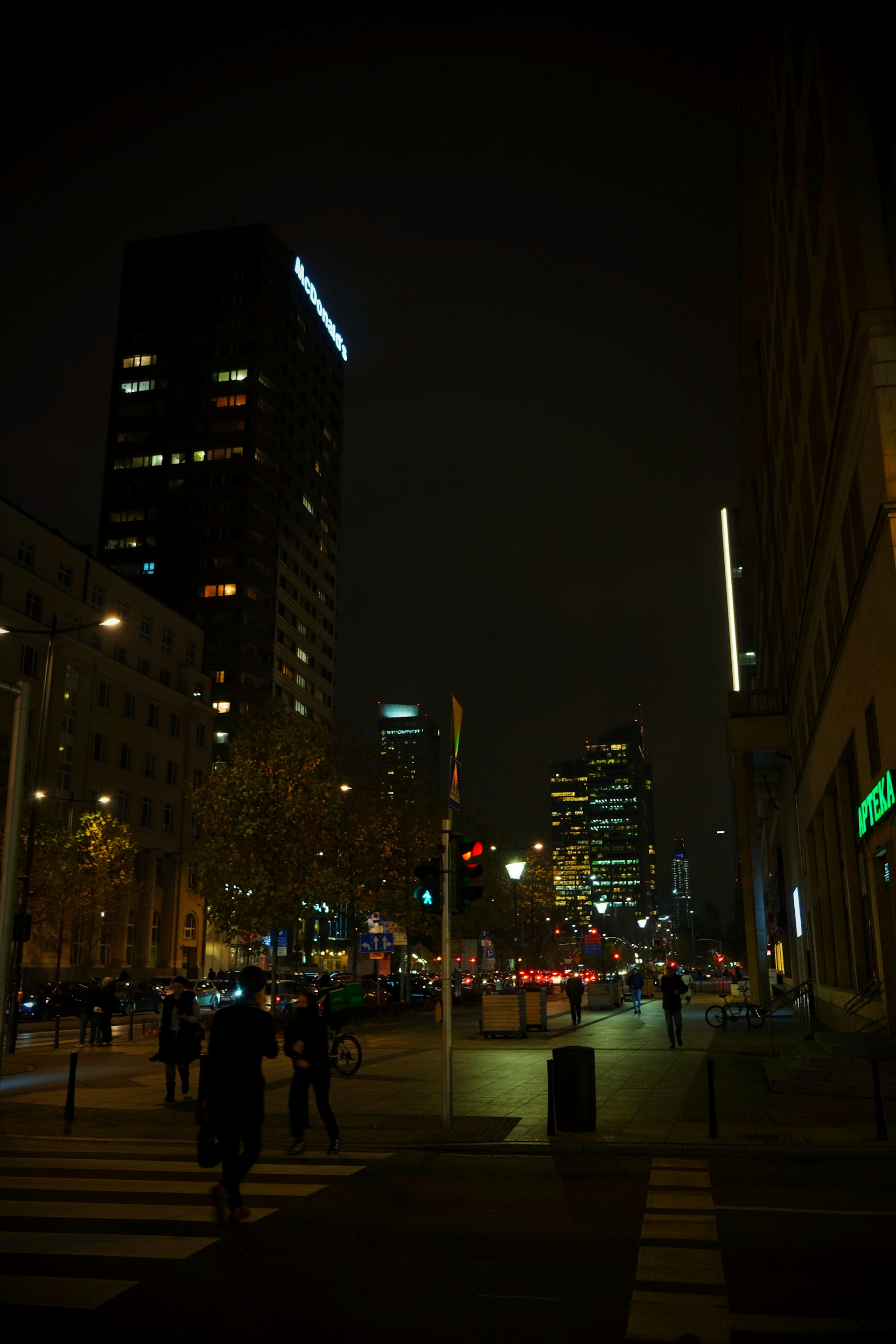 a group of people walking down a street at night