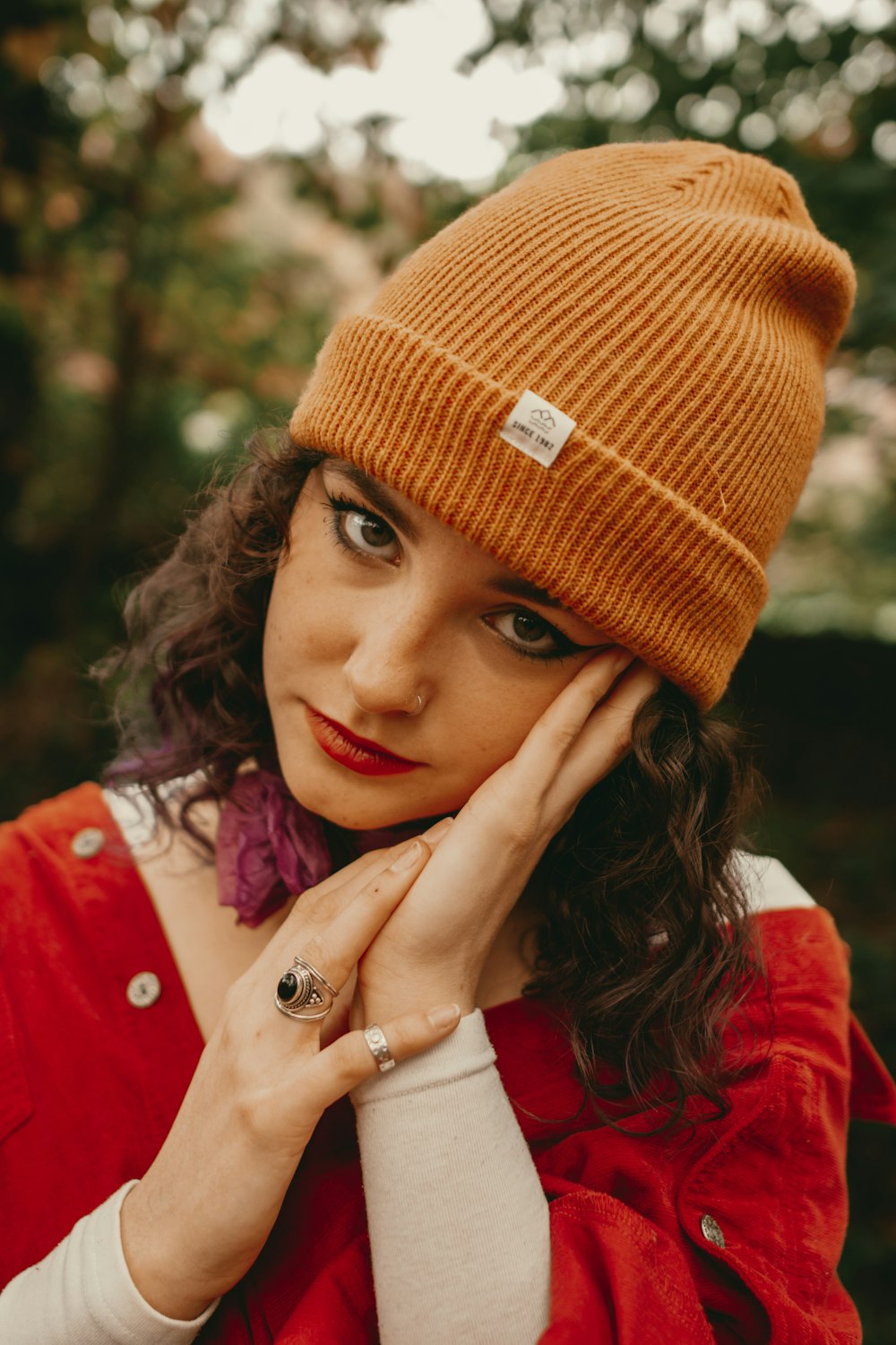 a woman wearing a red jacket and a brown hat