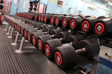 Row of new machines and weights arranged neatly in the weightlifting section