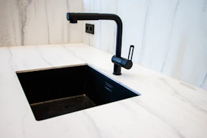 Modern kitchen sink setup with matte black fixtures and natural light