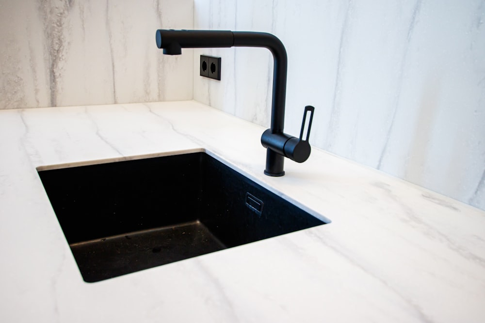 a kitchen sink with a black faucet over it