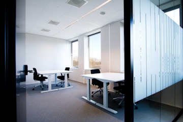 an office with a white table and black chairs