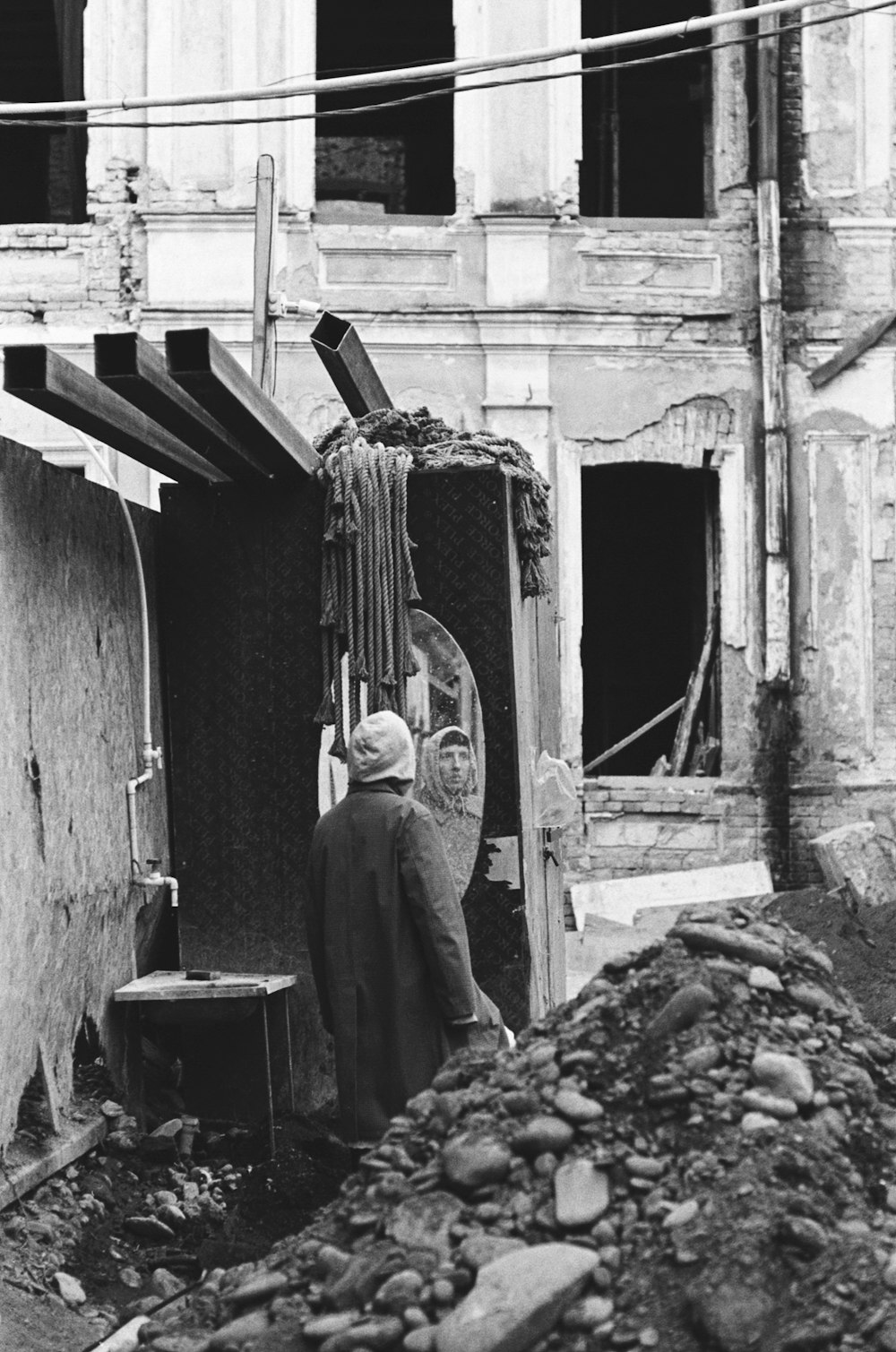 a black and white photo of a man standing in a doorway