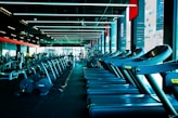 a row of exercise machines in a gym