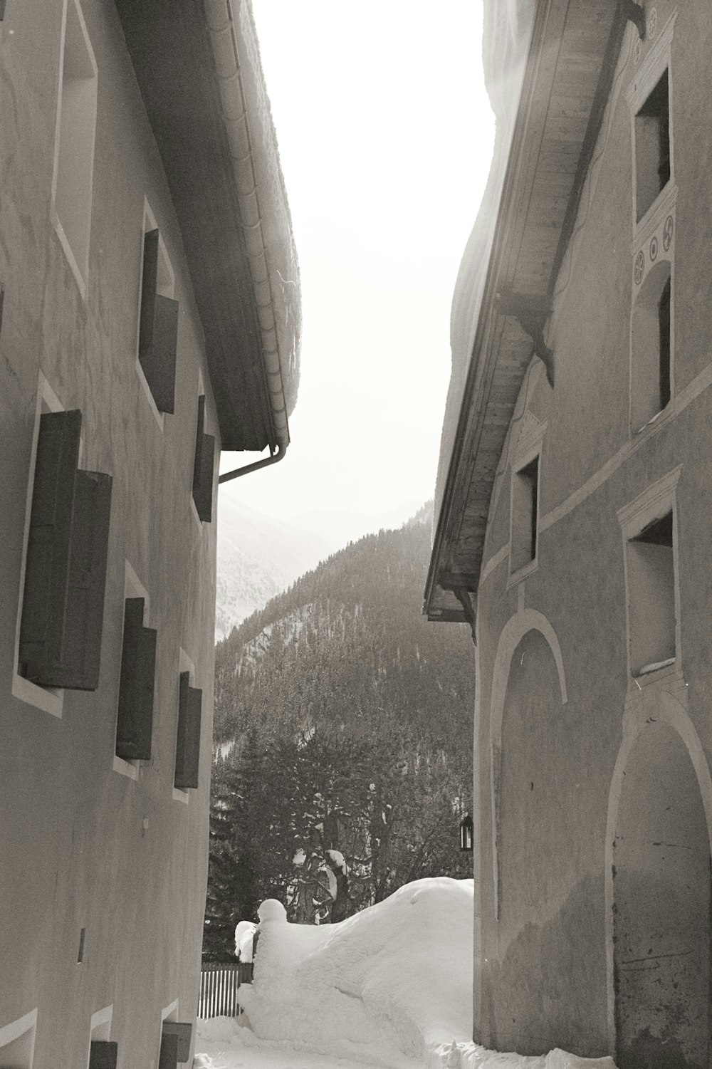雪の中の2つの建物の白黒写真