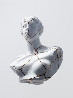 Elegant off-white decorative sculpture with gold matte accents.