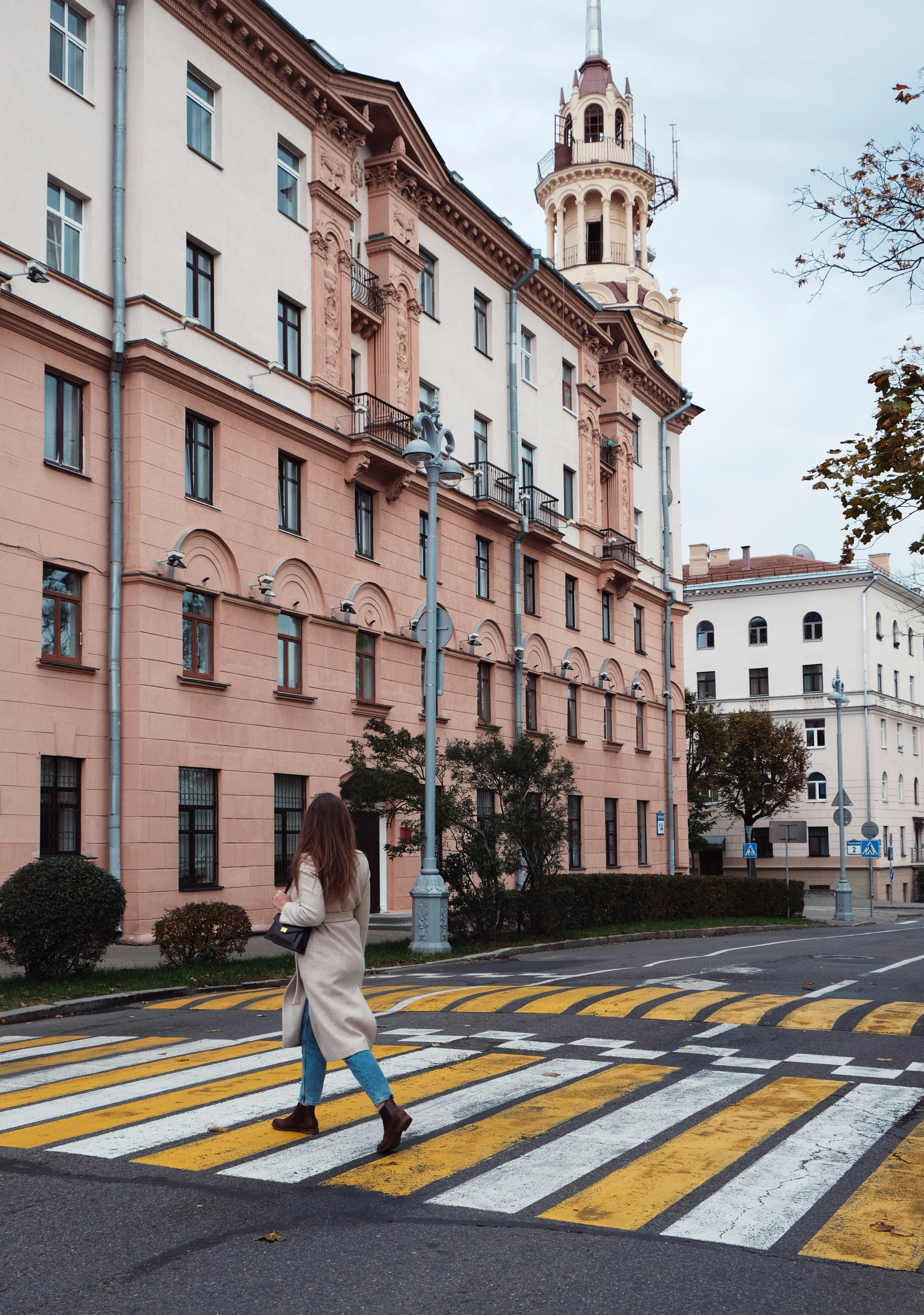 a person walking down a street next to a building