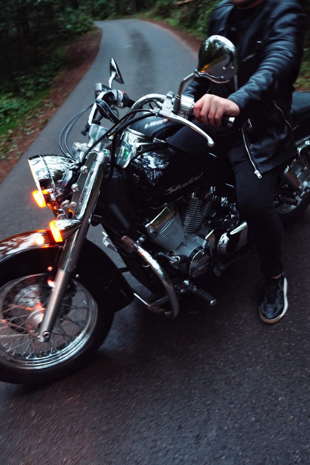 a man riding on the back of a motorcycle down a road