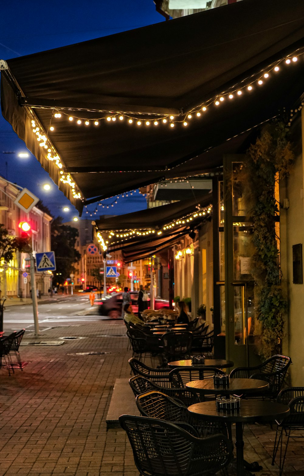 a sidewalk with tables and chairs on it