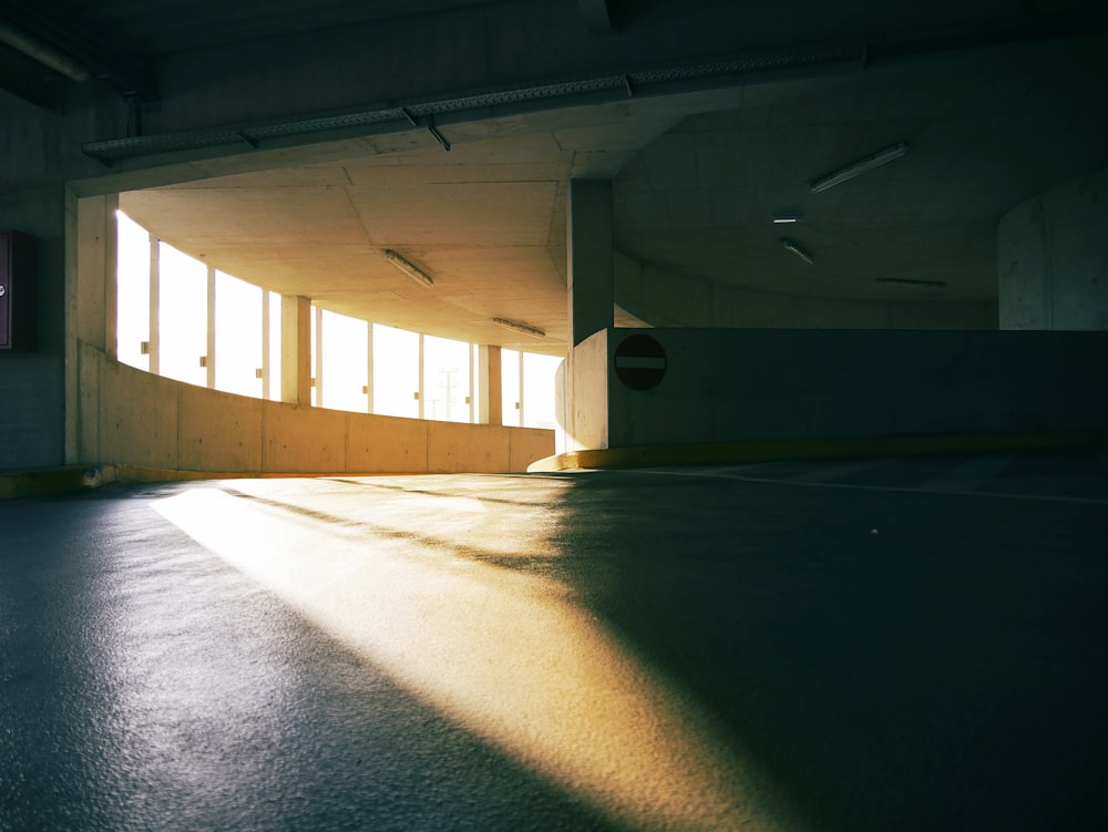 an empty parking garage with sun shining through the windows