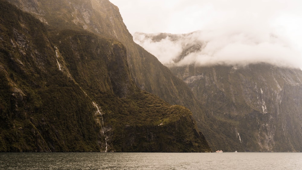 a boat in a body of water surrounded by mountains