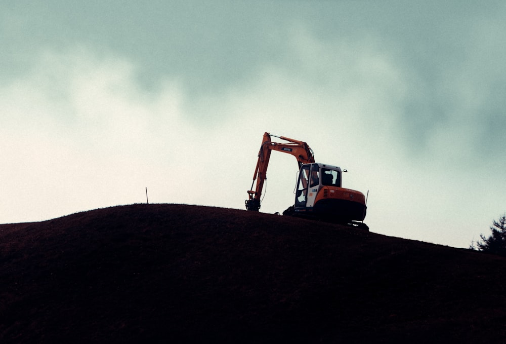 a bulldozer on top of a hill on a cloudy day