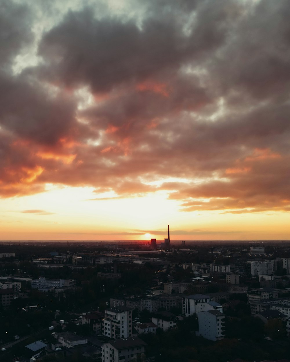 the sun is setting over a city with tall buildings