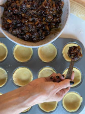 Hands carefully filling medjool dates with creamy peanut butter and walnuts.