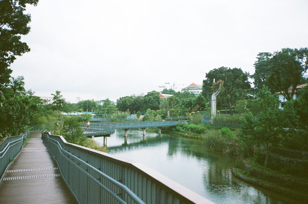 Eine Holzbrücke über einen Fluss neben einem üppigen grünen Wald