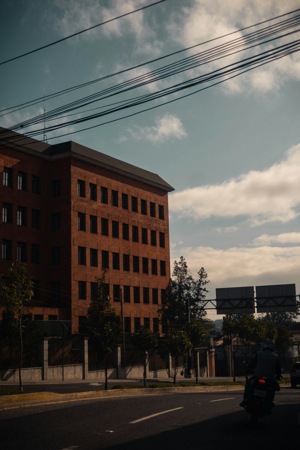 a motorcycle driving down a street next to a tall building