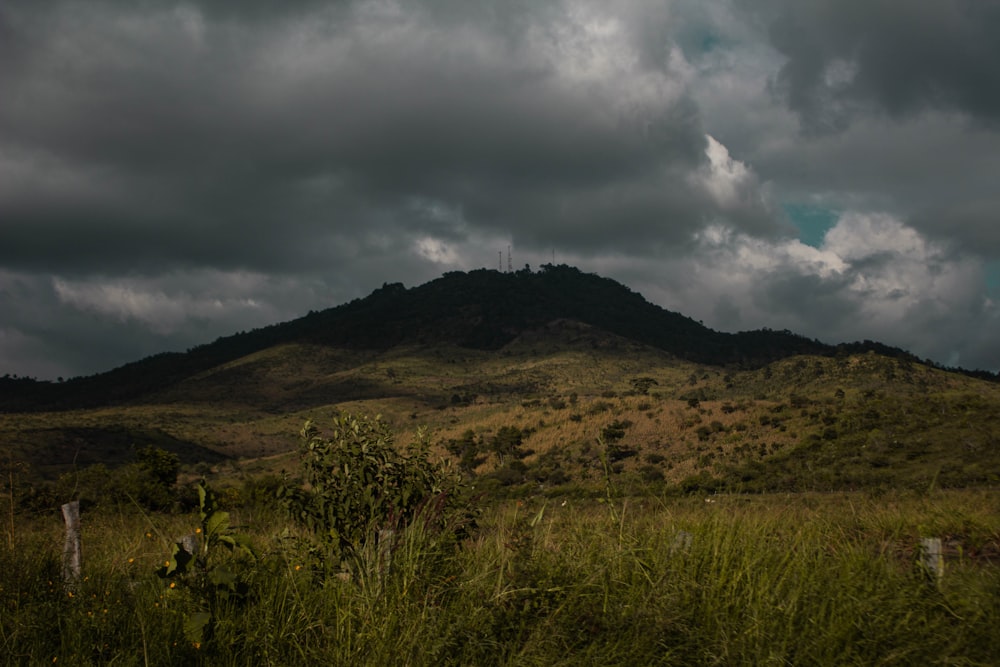 a large hill with a few clouds in the sky