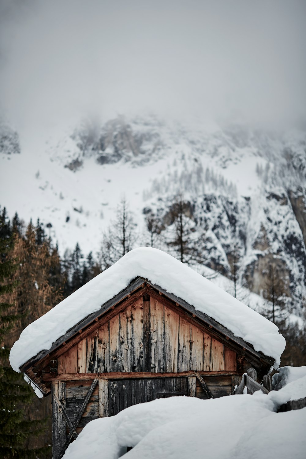 a cabin in the mountains covered in snow