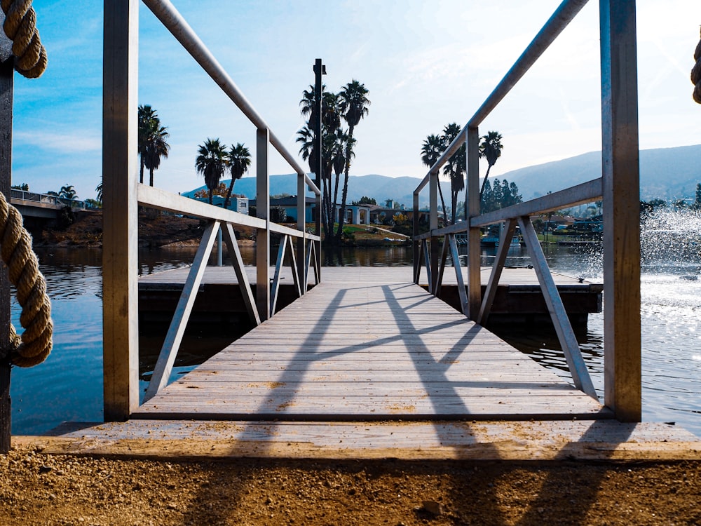 a dock with palm trees and a boat in the water