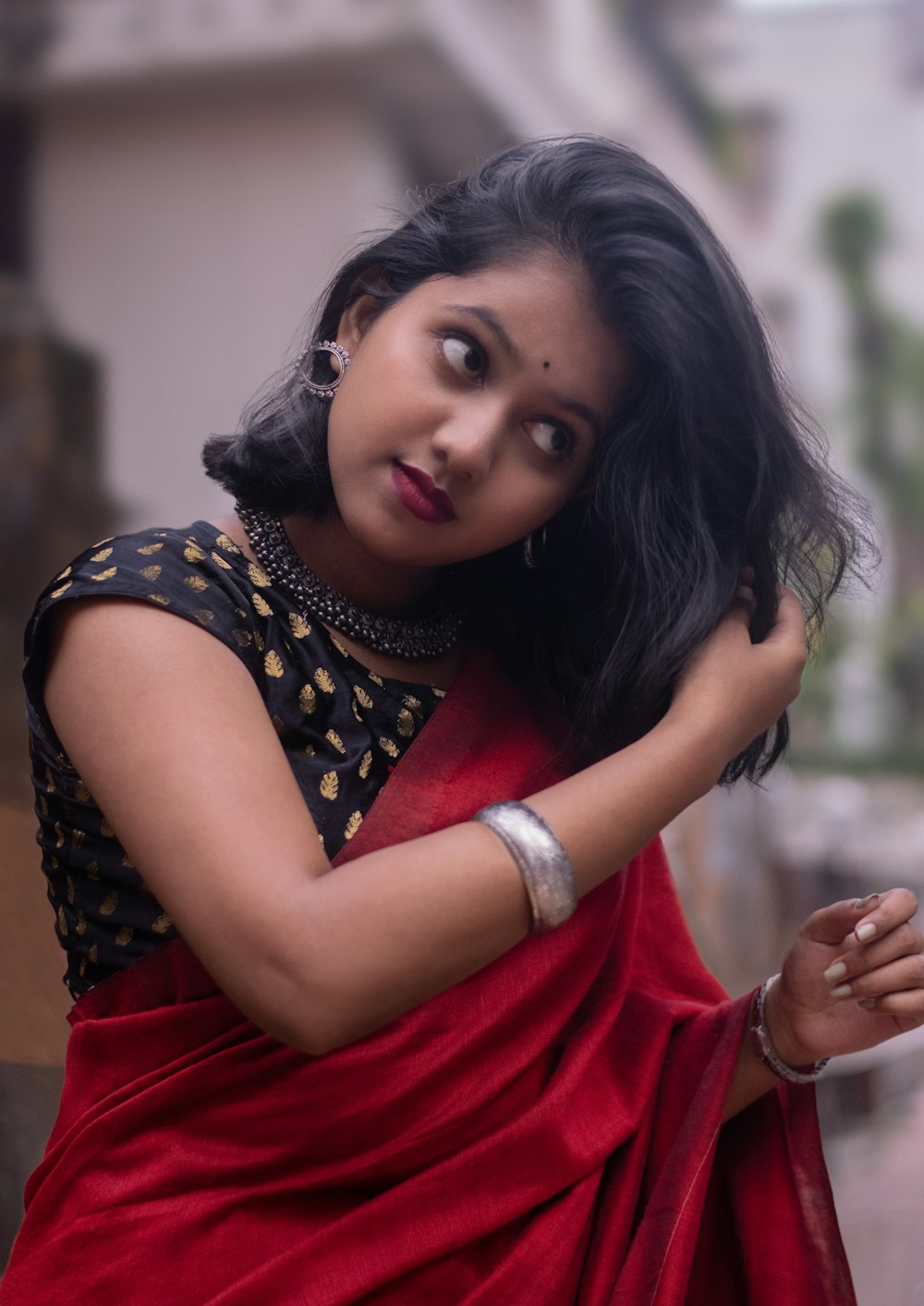 a woman in a red sari poses for a picture