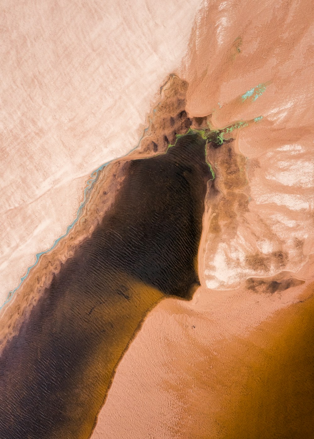 an aerial view of a sandy beach and water