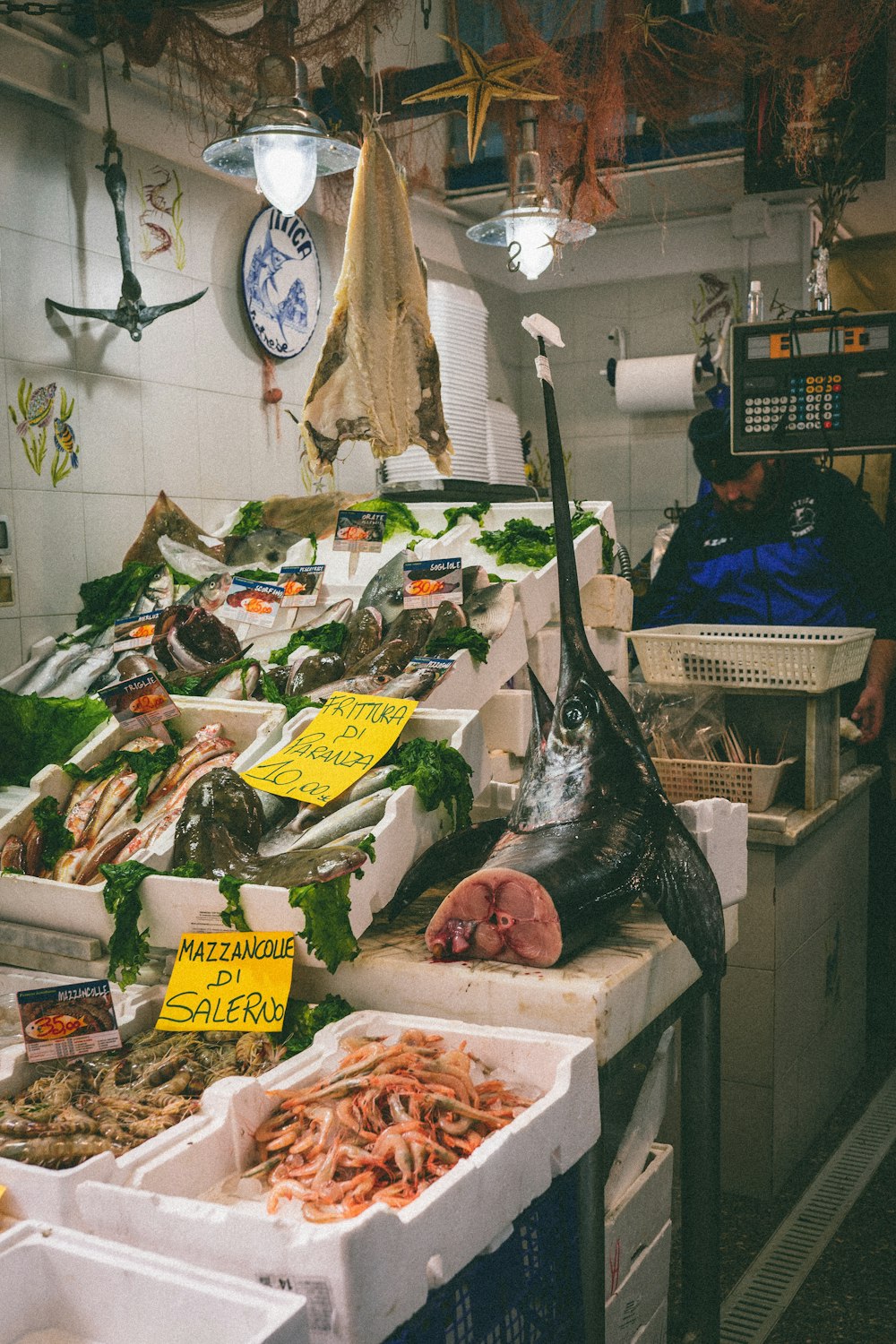 a man standing in front of a counter filled with seafood