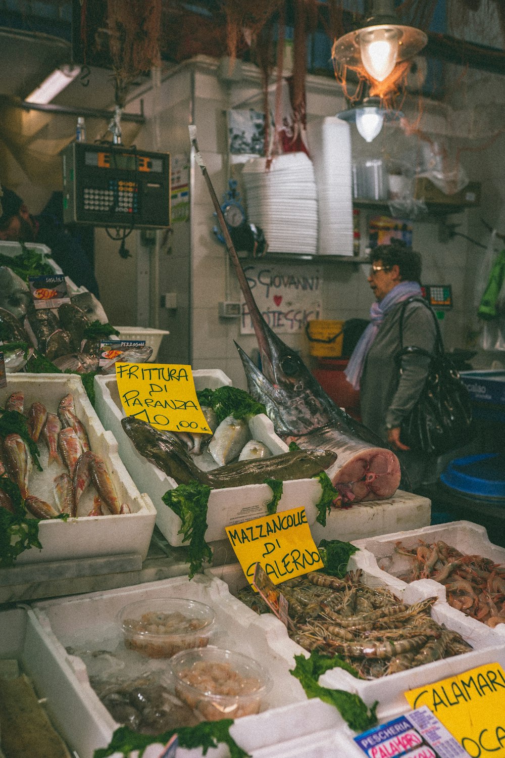 a man standing in front of a counter filled with seafood