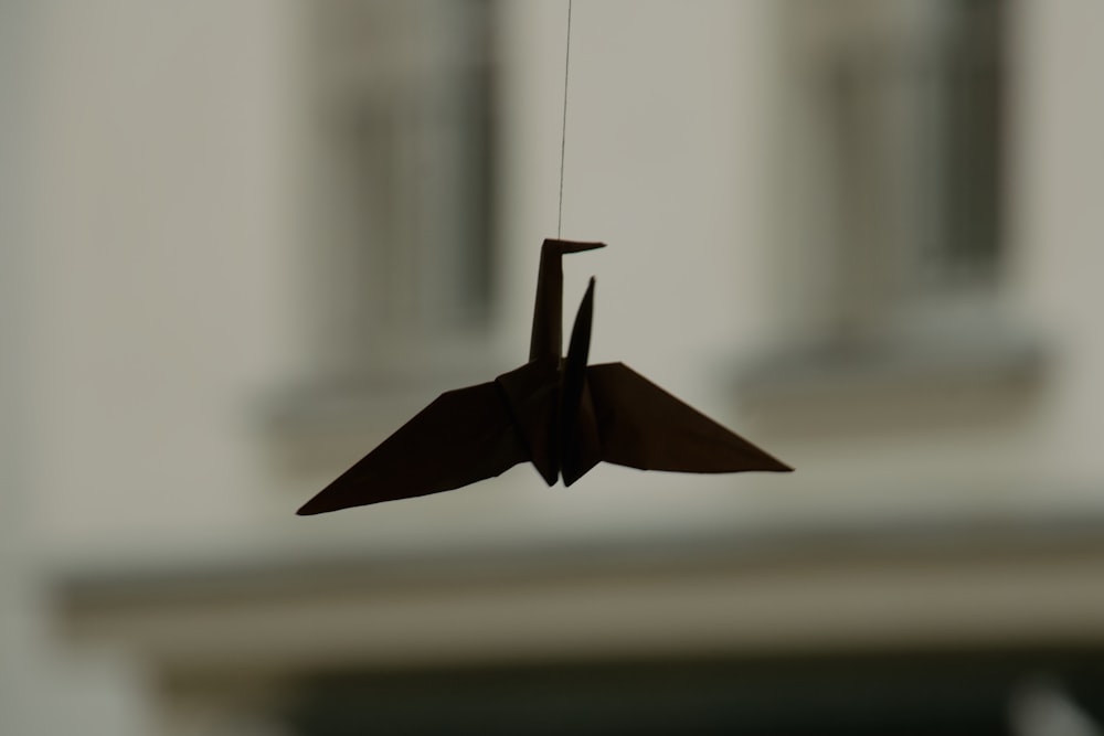 an origami bird hanging from a string